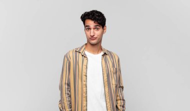 Aptal, çılgın, şaşkın bir ifadeyle genç yakışıklı adam, yanakları şişmiş, doldurulmuş, şişman ve yemekle dolu.