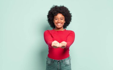  Mutlu bir şekilde gülümseyen, kendine güvenen, olumlu bakışlı, bir nesne ya da konsept sunan ve gösteren
