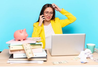 Masasında oturmuş dizüstü bilgisayarla çalışan güzel bir iş kadını.