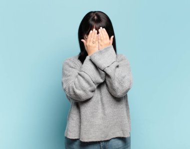 Artı boyut olarak güzel bir kadın üzgün, hayal kırıklığına uğramış, gergin ve depresif, iki eliyle yüzünü kaplayan, ağlayan