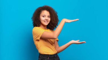  gülümseyen, mutlu, pozitif ve tatmin olmuş hisseden, kopya uzayı üzerinde nesne veya konsept tutan veya gösteren