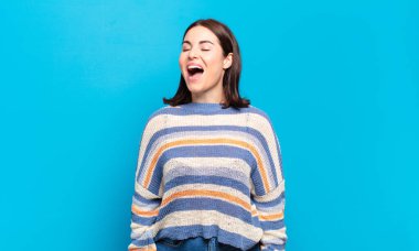 Genç ve güzel bir kadın öfkeyle bağırıyor, agresif bir şekilde bağırıyor, stresli ve kızgın görünüyor.