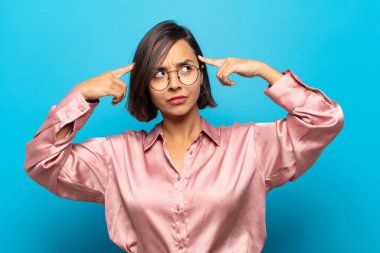 Genç İspanyol kadın kafası karışmış ya da şüpheye düşmüş, bir fikre odaklanmış, çok düşünüyor, kenarda boşluğu kopyalamak istiyor.