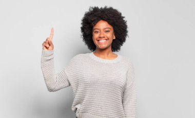  Neşeli ve mutlu bir şekilde gülümsüyor, tek eliyle uzayı kopyalıyor.