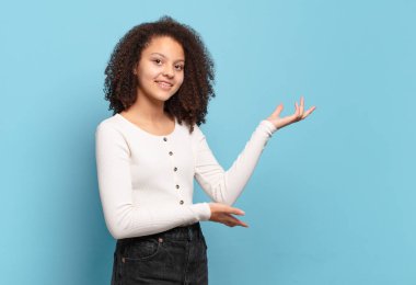  Gururla ve özgüvenle gülümseyen, mutlu ve tatmin olmuş hisseden ve fotokopi alanında bir konsept gösteren