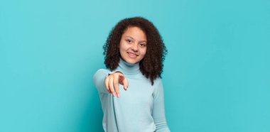  Tatmin olmuş, kendine güvenen, dost canlısı bir gülümsemeyle kameraya bakıp seni seçiyor.