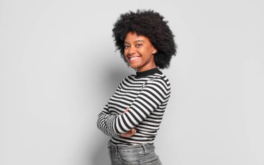  Kameraya çapraz kollarla gülümsüyor ve mutlu, kendinden emin, tatmin olmuş bir ifade, yan görüş.