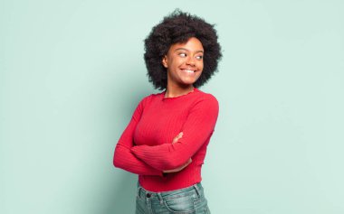  Neşeli bir şekilde gülümseyen, mutlu, tatmin olmuş ve rahatlamış hisseden, çapraz kollu ve yana bakan