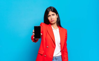 Genç İspanyol kadın üzgün ve mızmızlanıyor. Mutsuz bir bakışla. Olumsuz ve hayal kırıklığına uğramış bir tavırla ağlıyor. telefon ekran kopyalama alanı