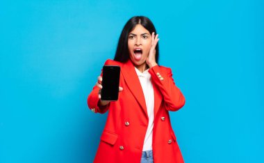 Genç İspanyol kadın mutlu, heyecanlı ve şaşırmış hissediyordu. İki eli de havada bir tarafa bakıyordu. telefon ekran kopyalama alanı