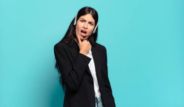 Genç İspanyol tele pazarlamacı kadın ağzı ve gözleri sonuna kadar açık ve eli çenesinde, nahoş bir şokta, ne ya da vay canına diyor.