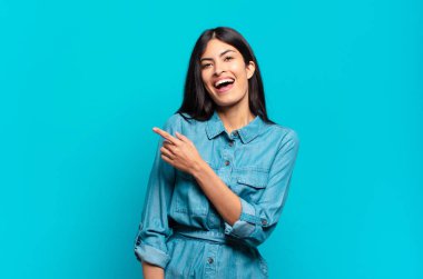 Genç Latin asıllı sıradan bir kadın heyecanlı ve şaşırmış görünüyor.