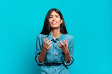 Genç Latin asıllı sıradan bir kadın umutsuz ve hayal kırıklığına uğramış görünüyor, stresli, mutsuz ve sinirli, bağırıyor ve çığlık atıyor.