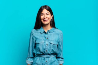 Genç Latin asıllı sıradan bir kadın mutlu ve hoş bir şekilde şaşırmış görünüyor. Büyülenmiş ve şok olmuş bir ifadeyle heyecanlanıyor.