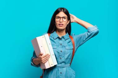 Genç İspanyol öğrenci kadın kendini stresli, endişeli ya da korkmuş hissediyor. Elleri başının üstünde, hatayla panikliyor.