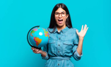 Genç İspanyol kadın mutlu, heyecanlı, şaşırmış ya da şok olmuş hissediyor. İnanılmaz bir şeye gülümsüyor ve hayrete düşüyor. Toprak gezegeni konsepti