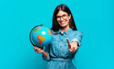 Genç İspanyol kadın gülümsüyor ve arkadaş canlısı görünüyor, bir numara ya da ilk eli önde, geriye doğru sayıyor. Toprak gezegeni konsepti