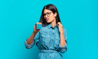 Genç İspanyol kadın stresli, endişeli, yorgun ve hayal kırıklığına uğramış, gömleğini çekmiş, sorunlu görünüyor. zeka problemi kavramı