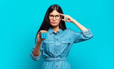 Genç İspanyol kadın şaşkın ve şaşkın hissediyor. Deli, deli ya da aklını kaçırmış olduğunu gösteriyor. zeka problemi kavramı