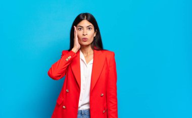 Genç İspanyol iş kadını, ağzı açık bir şekilde yüz yüze inanmayarak şok olmuş ve hayrete düşmüş hissediyor.