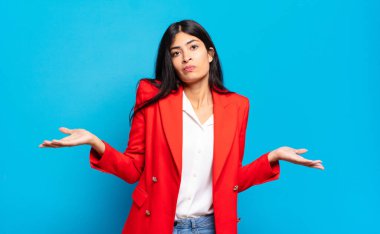 Genç İspanyol iş kadını şaşkın ve şaşkın hissediyor, doğru cevap ya da karardan emin değil, bir seçim yapmaya çalışıyor.