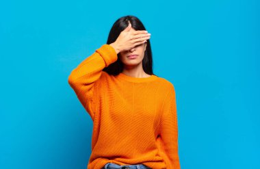 Genç ve güzel İspanyol bir kadın tek eliyle gözlerini kapatıyor. Korkmuş ya da endişeli, merak ediyor ya da körü körüne bir sürpriz bekliyor.