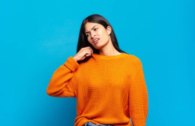 Genç, güzel, İspanyol bir kadın stresli, endişeli, yorgun ve hayal kırıklığına uğramış, gömleğini çekmiş, sıkıntılı görünüyor.