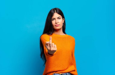 Genç ve güzel İspanyol bir kadın kızgın, sinirli, asi ve agresif hissediyor, orta parmağını sallıyor, karşı koyuyor.