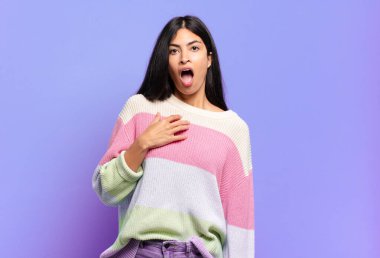 Genç ve güzel İspanyol kadın şok olmuş, şaşırmış ve şaşırmış hissediyor, elleri göğsünde ve ağzı açık, kim olduğumu söylüyor, ben mi??