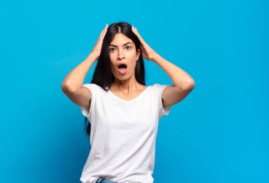 Genç, güzel, İspanyol bir kadın heyecanlı ve şaşırmış görünüyor. İki eli de başının üstünde, kendini şanslı bir kazanan gibi hissediyor.