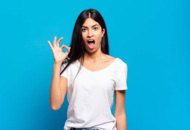 Genç, güzel İspanyol bir kadın kendini başarılı ve tatmin olmuş hissediyor ağzı açık gülümsüyor, elle imza atıyor.