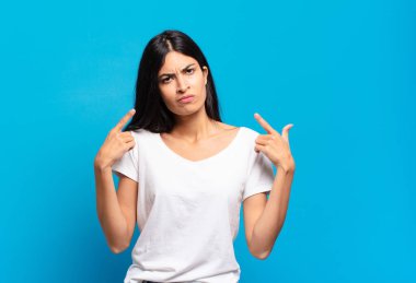 Genç, güzel, kötü tavırlı, gururlu ve agresif görünümlü, yukarıyı gösteren ya da elleriyle alay eden İspanyol bir kadın.