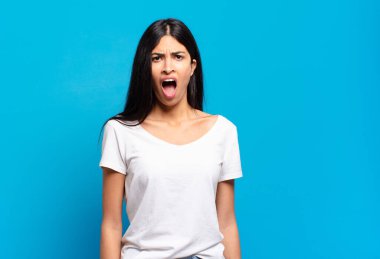 Genç ve güzel İspanyol kadın korkmuş ve şok olmuş hissediyor, ağzı açık şaşkınlık içinde.