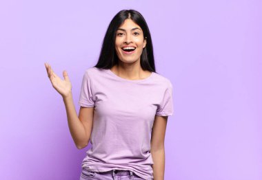 Genç, güzel, İspanyol bir kadın mutlu, şaşırmış ve neşeli hissediyor. Pozitif bir tavırla gülümsüyor. Bir çözüm ya da fikrin farkına varıyor.