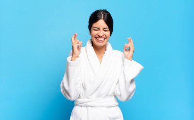 Genç İspanyol kadın gergin ve umutlu, şans diliyor ve dua ediyor. Bornoz konsepti