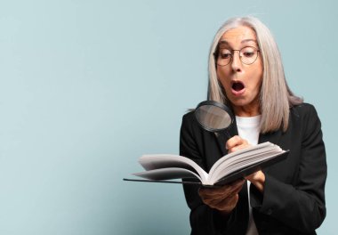 Elinde kitap ve büyüteçle son sınıf güzeli bir kadın. arama konsepti