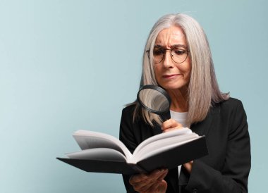 Elinde kitap ve büyüteçle son sınıf güzeli bir kadın. arama konsepti