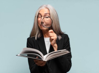 Elinde kitap ve büyüteçle son sınıf güzeli bir kadın. arama konsepti