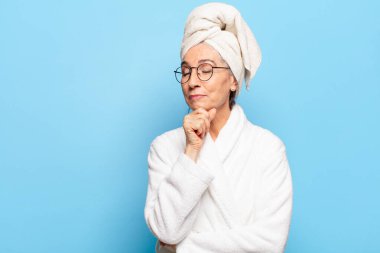 Duştan sonra bornoz giyen yaşlı ve güzel bir kadın.