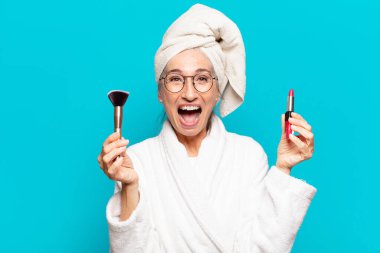 Duştan sonra giyinmiş, makyajlı ve bornozlu hoş bir kadın.