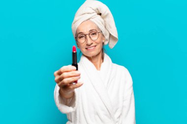 Duştan sonra giyinmiş, makyajlı ve bornozlu hoş bir kadın.