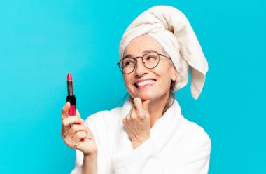 Duştan sonra giyinmiş, makyajlı ve bornozlu hoş bir kadın.