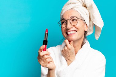 Duştan sonra giyinmiş, makyajlı ve bornozlu hoş bir kadın.