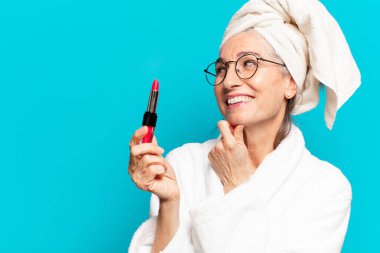 Duştan sonra giyinmiş, makyajlı ve bornozlu hoş bir kadın.