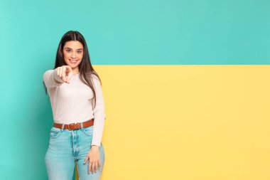 Genç ve güzel bir kadın kameraya bakıyor. Tatmin olmuş, kendinden emin, dostane bir gülümsemeyle. Seni seçiyor. Konseptinizi yerleştirmek için boşluk kopyalayın