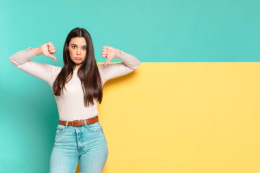 Genç, güzel bir kadın üzgün, hayal kırıklığına uğramış ya da kızgın görünüyor, anlaşmazlık içinde parmaklarını gösteriyor, hayal kırıklığına uğramış hissediyor. Konseptinizi yerleştirmek için boşluk kopyalayın