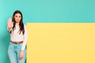 Genç ve güzel bir kadın ciddi, sert, hoşnutsuz ve kızgın görünüyor. Konseptinizi yerleştirmek için boşluk kopyalayın