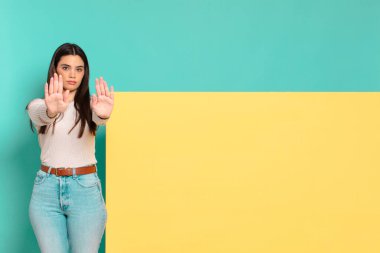 Genç ve güzel bir kadın ciddi, mutsuz, kızgın ve hoşnutsuz görünüyor. Ya da her iki avucunun içinde de dur diyor. Konseptinizi yerleştirmek için boşluk kopyalayın