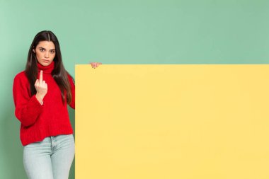 young pretty woman feeling angry, annoyed, rebellious and aggressive, flipping the middle finger, fighting back. copy space to place your concept