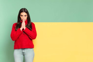 young pretty woman feeling worried, hopeful and religious, praying faithfully with palms pressed, begging forgiveness. copy space to place your concept